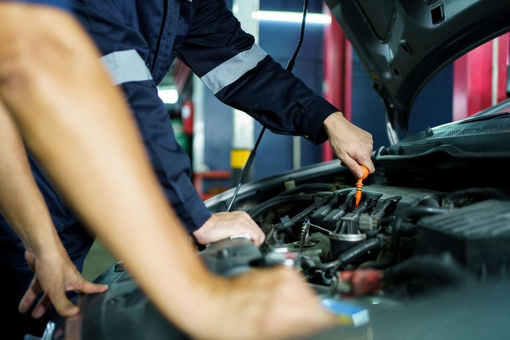 A Group Of Mechanics Are Working On A Car In A Garage — Josh's Diesel Services in Boyne Island, QLD