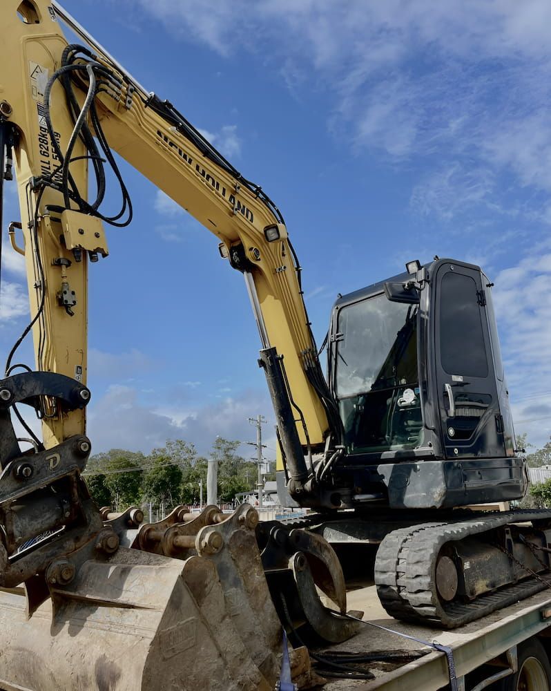 A Yellow Excavator Is Sitting On Top Of A Truck — Josh's Diesel Services in Bororen, QLD