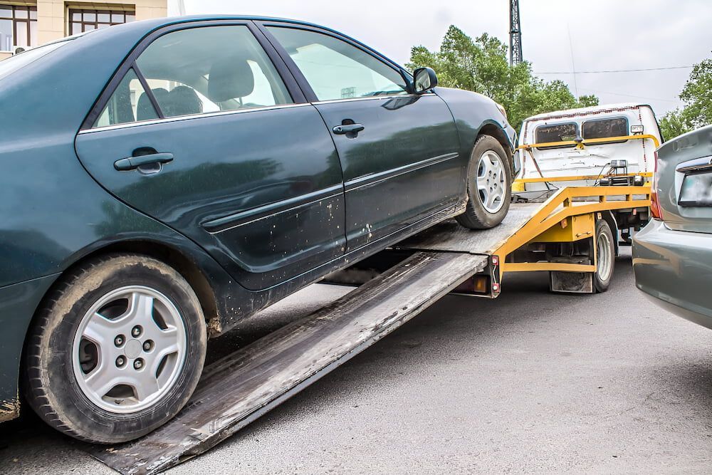 A Car Is Being Towed By A Tow Truck — Josh's Diesel Services in Boyne Island, QLD