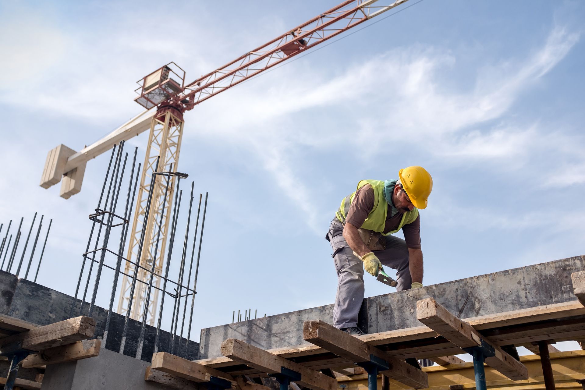 Un trabajador de la construcción está trabajando en un tejado en una obra en construcción.