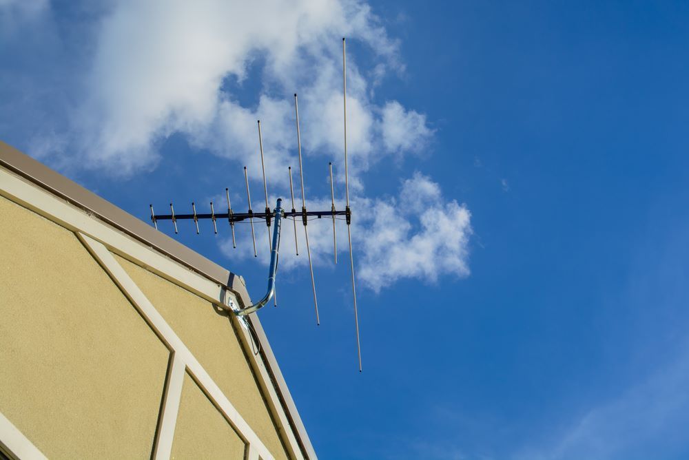 A Television Antenna on a Beige Building Roof — BTV Antenna & Data in Woodgate, QLD