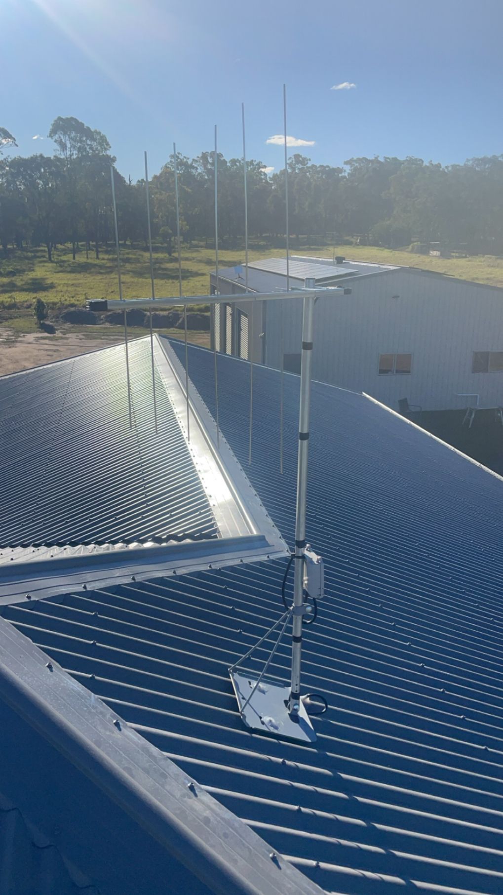 A Man Is Installing a Satellite Dish on The Roof of A Building — BTV Antenna & Data in Coral Cove, QLD