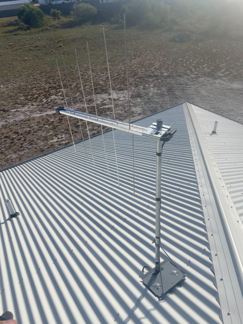 A Man Is Sitting on A Ladder Working on An Antenna — BTV Antenna & Data in Coral Cove, QLD