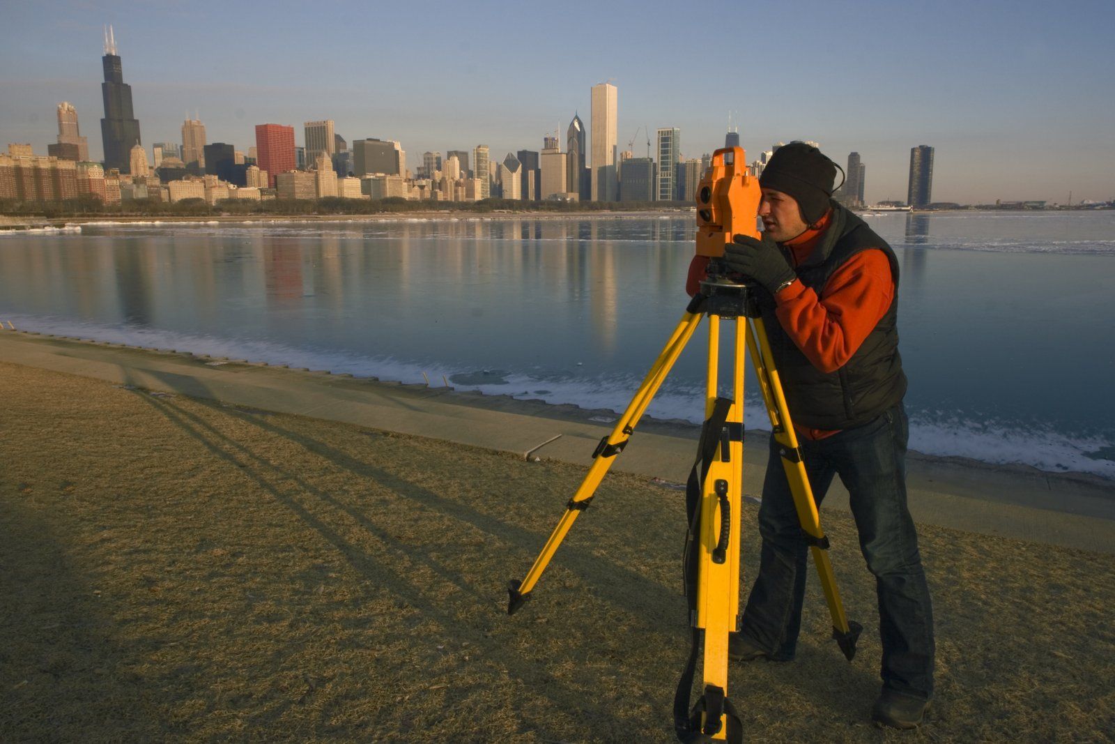 A man standing on a beach with a city skyline in the background