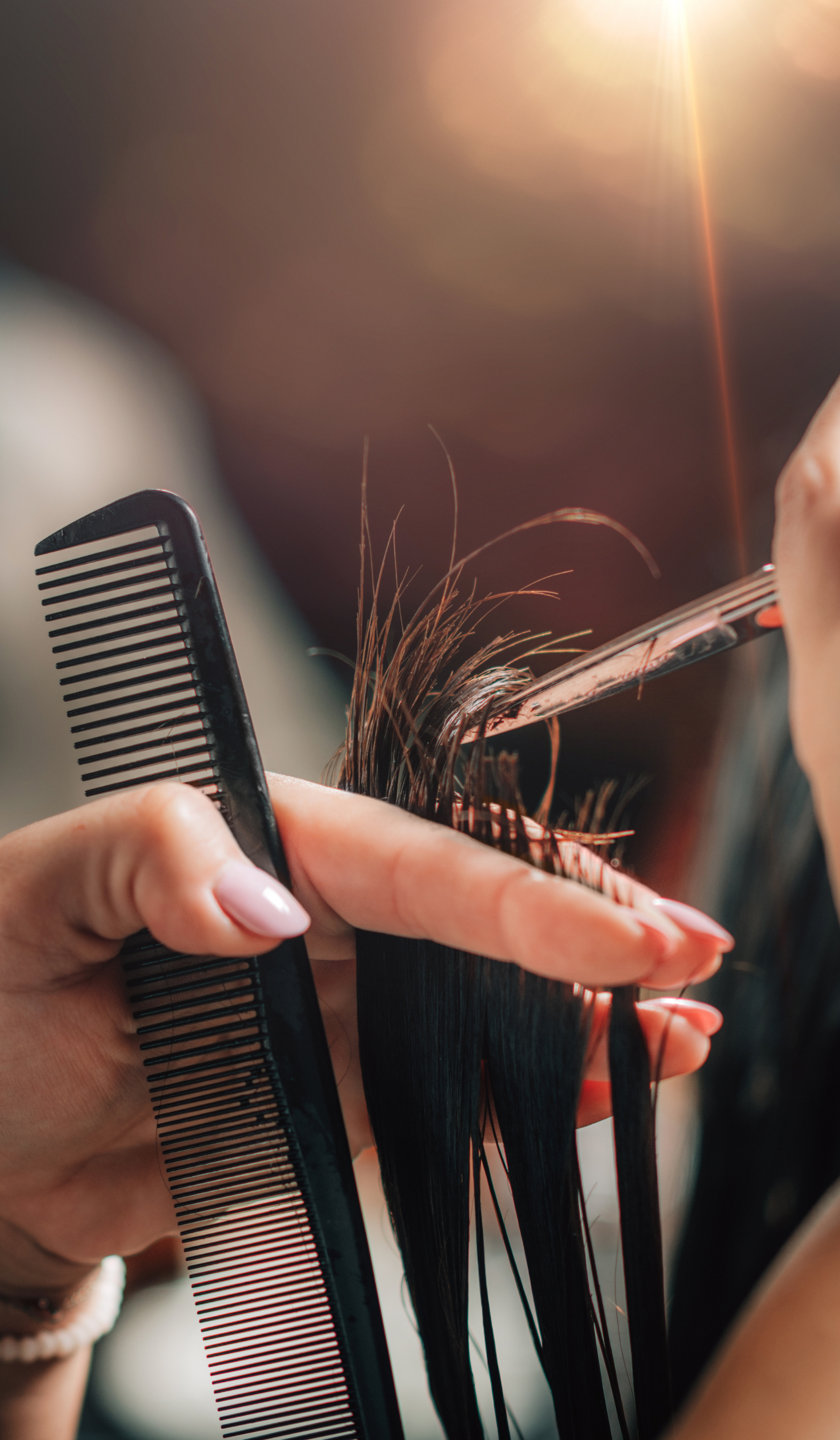 a woman is getting her hair cut by a hairdresser while holding a comb .