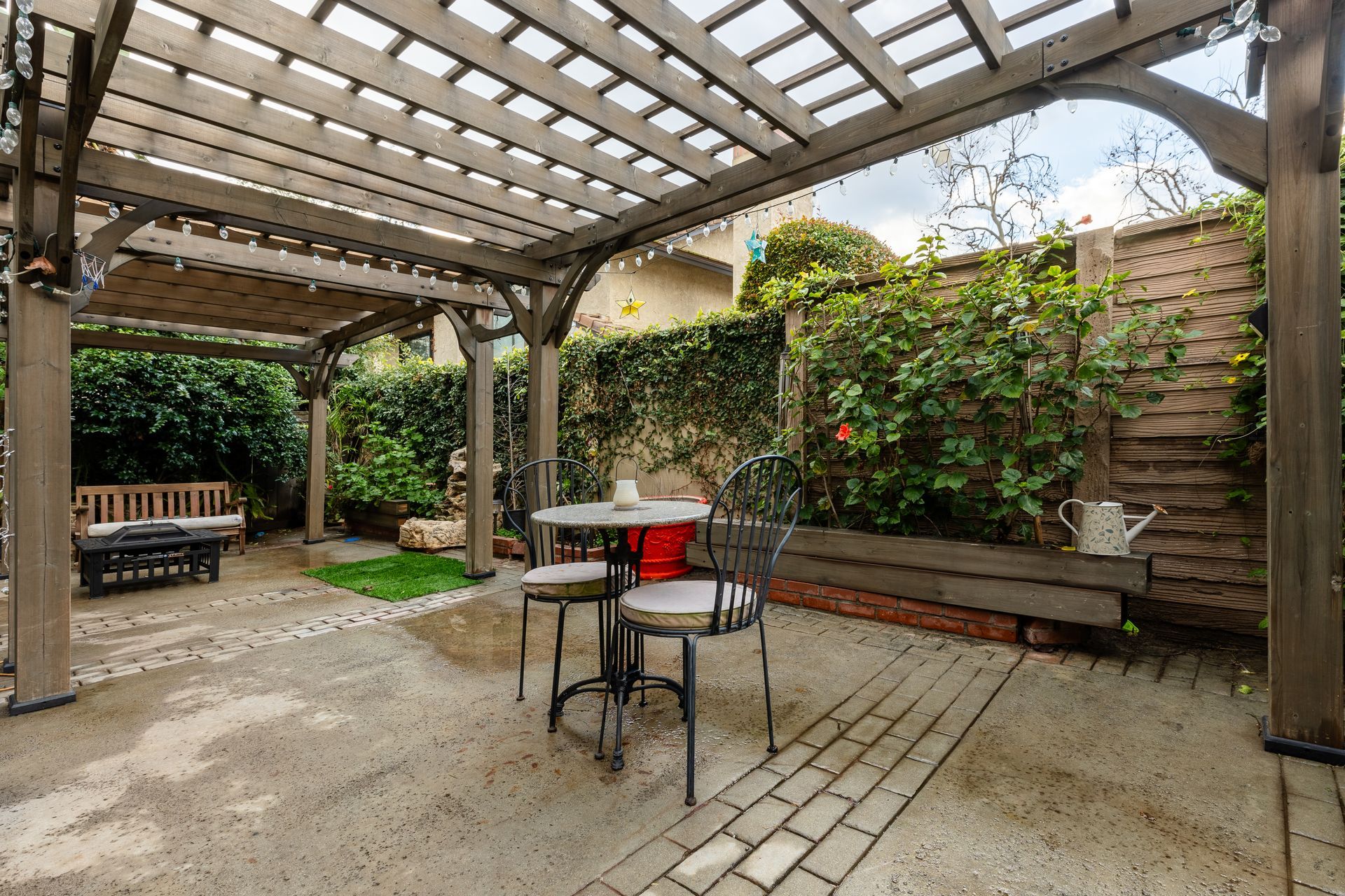 A patio with a table and chairs under a pergola.