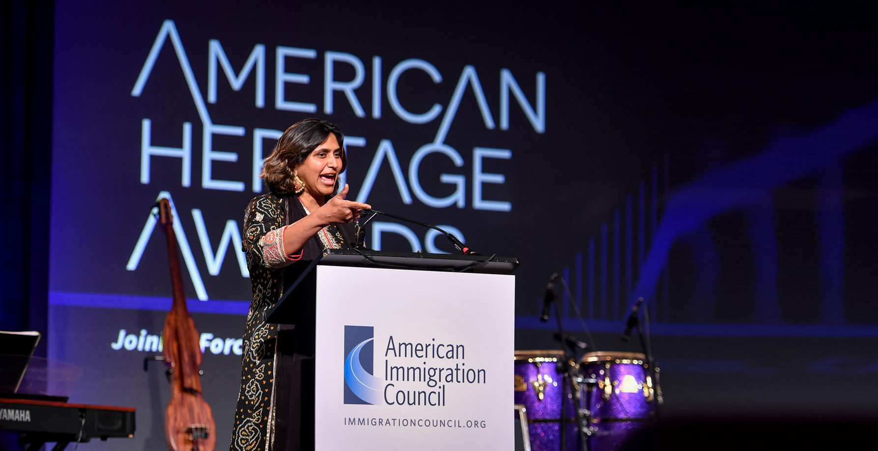 a woman is standing at a podium giving a speech at the american heritage awards .