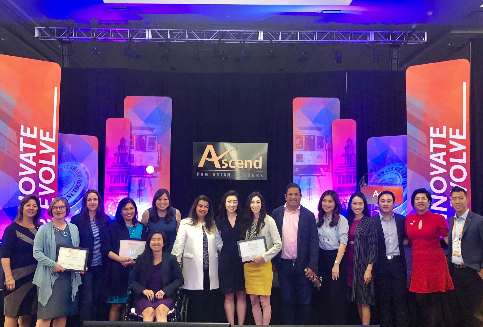 a group of people are posing for a picture on a stage at the Ascend National Convention.