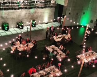 a group of people are sitting at tables at the Smithsonian National Museum of American History for the NCGA event.