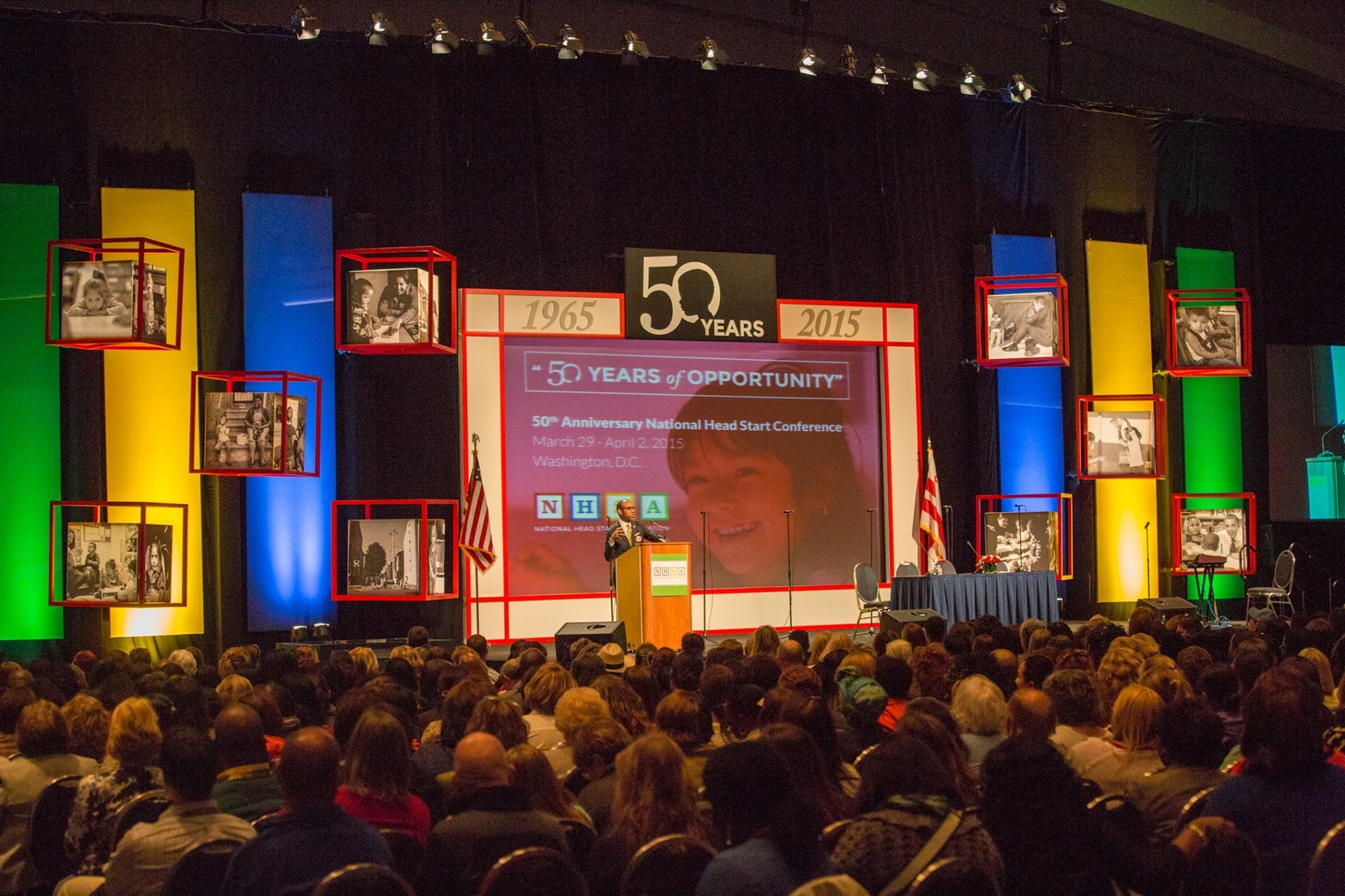 a man stands at a podium in front of a crowd at the NHSA 50th anniversary event