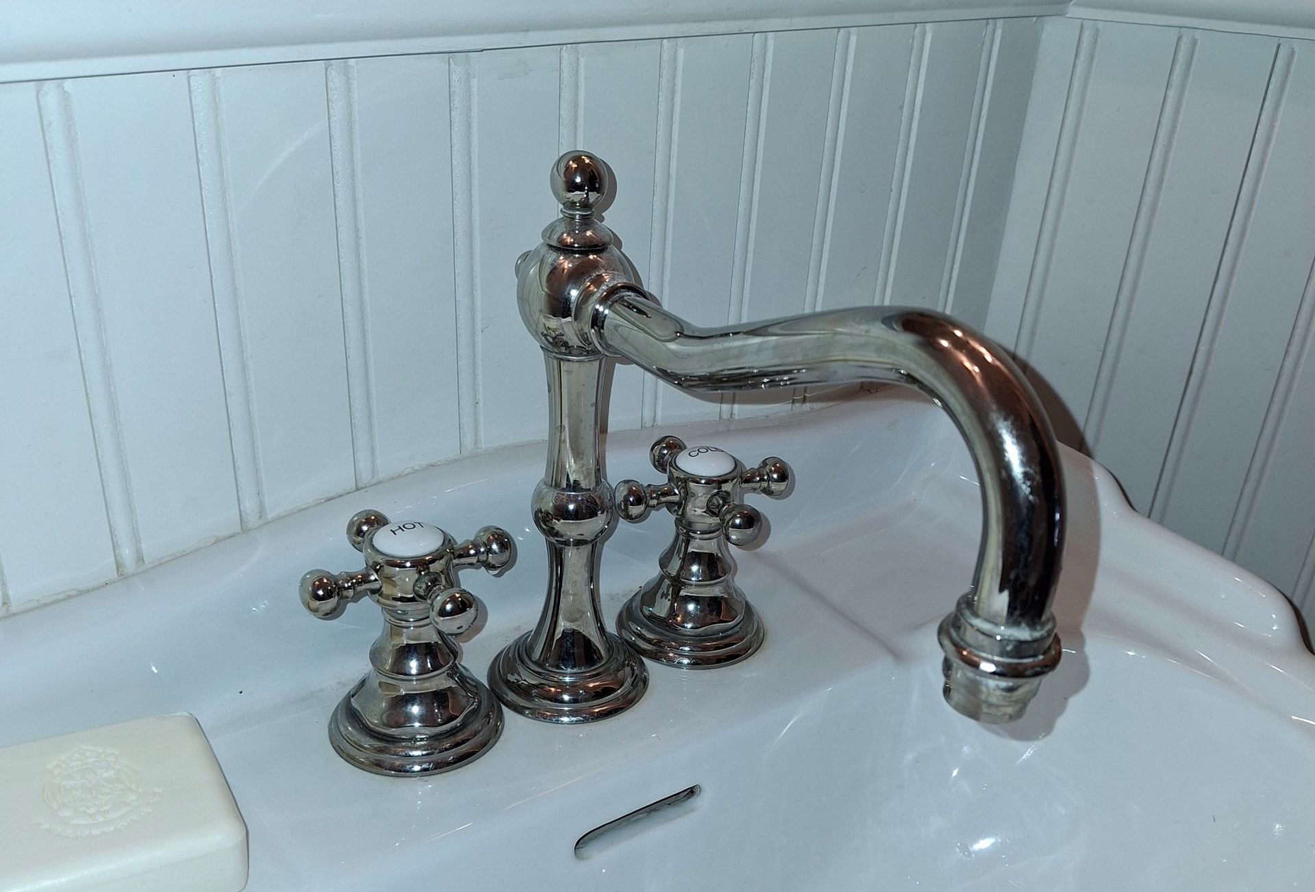 A man is fixing a shower head in a bathroom