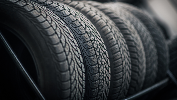 Tires stacked in a row, showcasing their tread pattern.