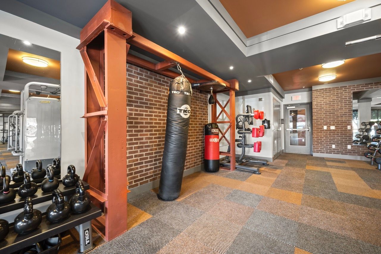 Indoor gym area with punching bag, kettlebells, and weight racks.
