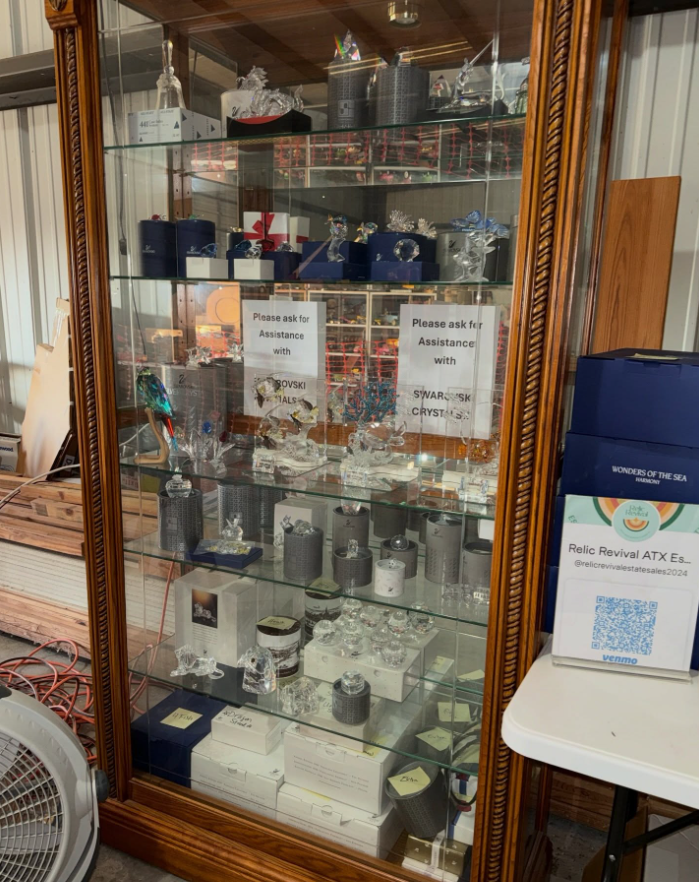 A tall, wood-framed glass display cabinet filled with various small gift items, figurines, and boxes inside a retail space.