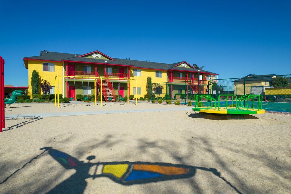A large yellow building with a playground in front of it