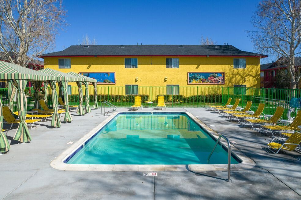 A large swimming pool in front of a yellow building