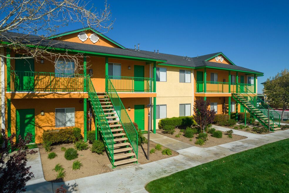 A colorful apartment building with green stairs and balconies