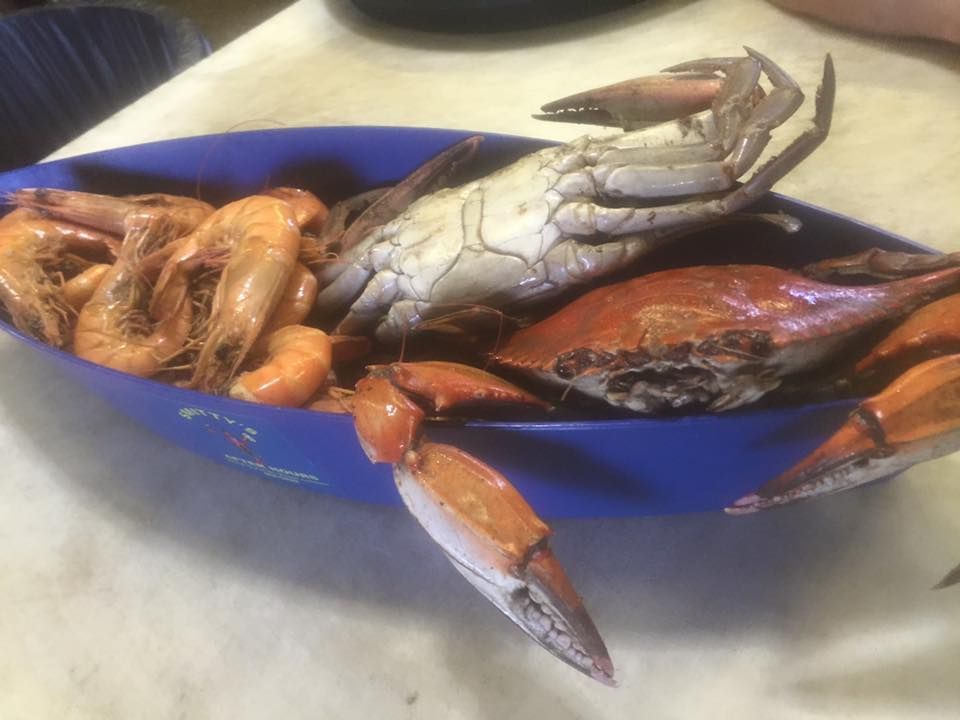 A blue bowl filled with shrimp and crabs on a table