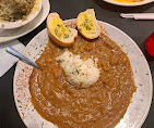 A white plate topped with rice and garlic bread. A white plate topped with rice and garlic bread.