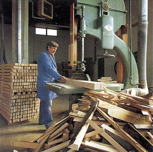 Falegname in magazzino con prodotti in legno