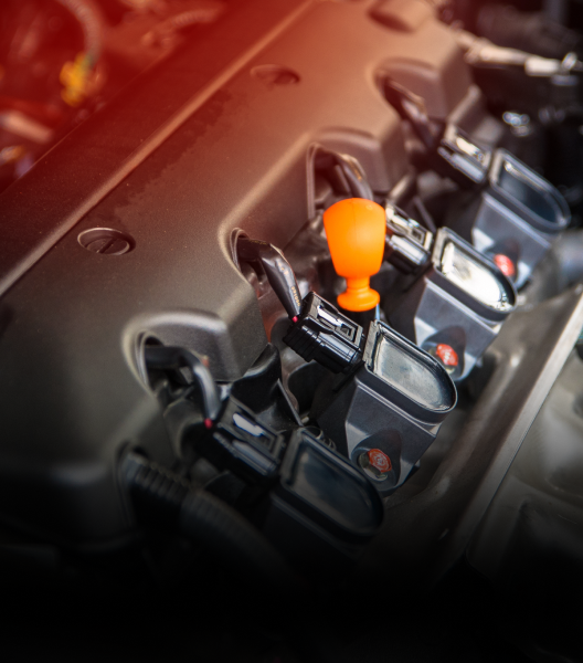Engine bay with ignition coils and an orange tool | NOR-CAL AUTOMOTIVE