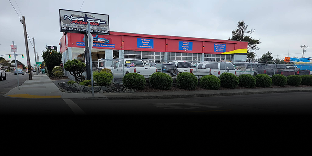 A car dealership with a red roof and sign. Cars are parked in front of the building | NOR-CAL AUTOMOTIVE