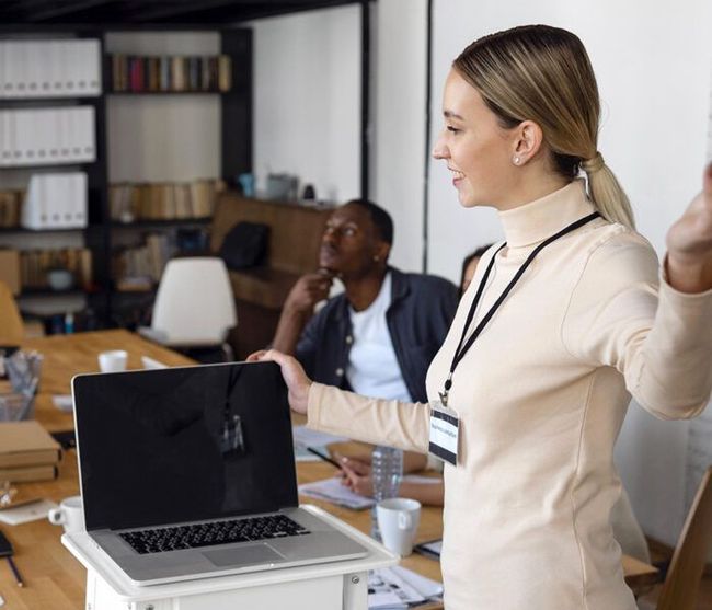 A woman is giving a presentation in front of a laptop computer.