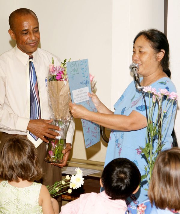 A woman is giving a man a bouquet of flowers.