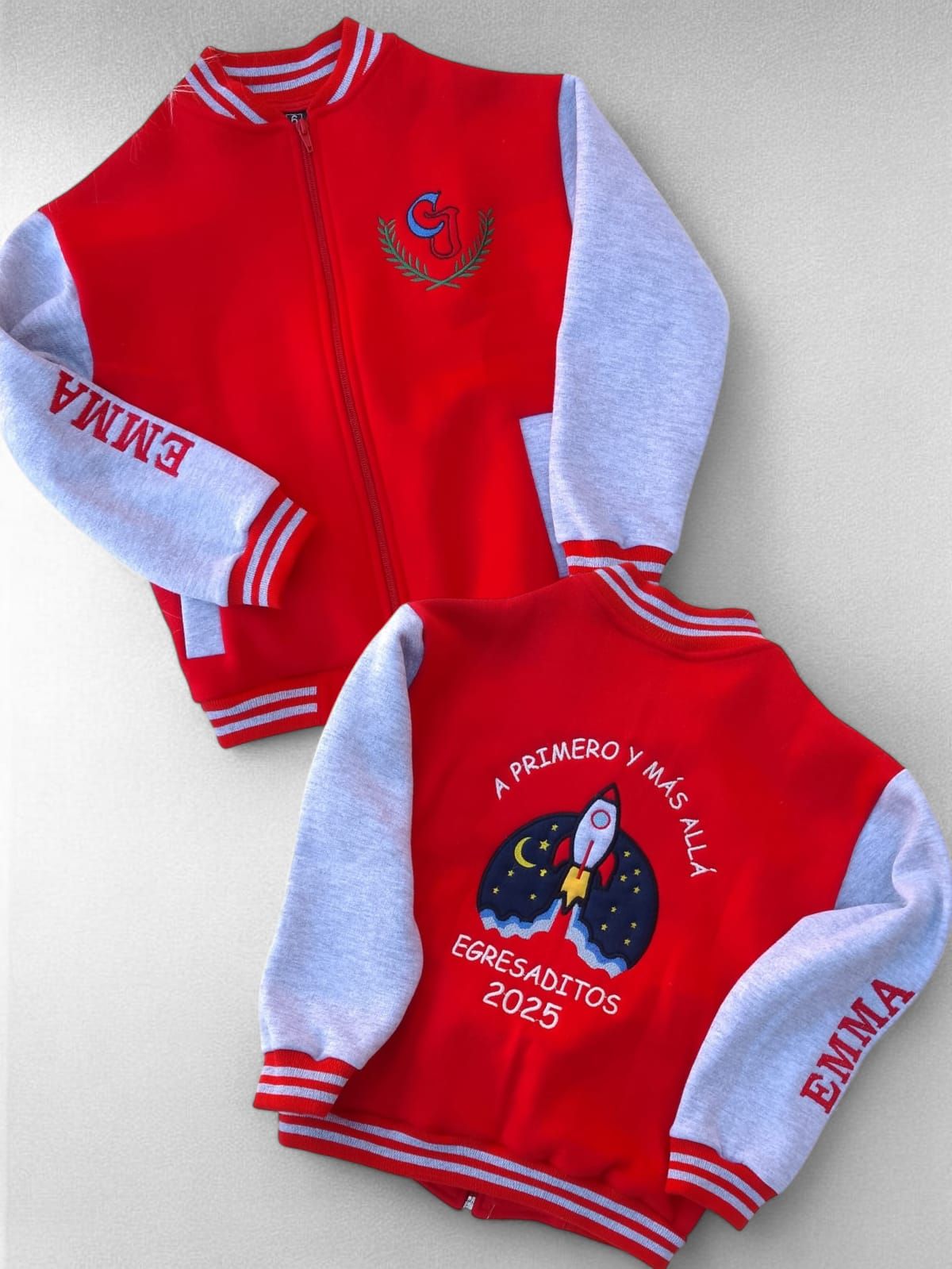 Chaqueta universitaria roja y gris con "EMMA" en las mangas y diseño bordado en la espalda.