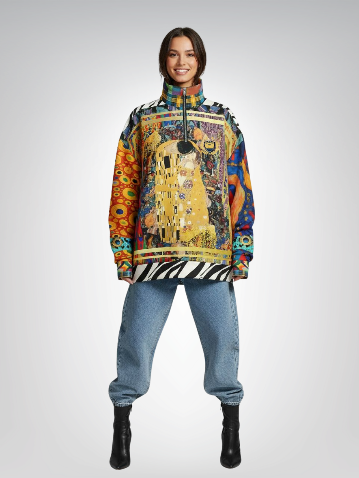 Woman wearing a zip-up sweatshirt with a colorful artwork design, standing with jeans and boots.