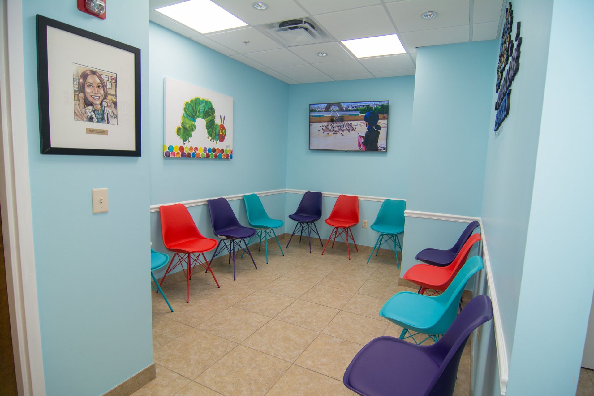 photo of the waiting room with blue, purple and red chairs against the walls