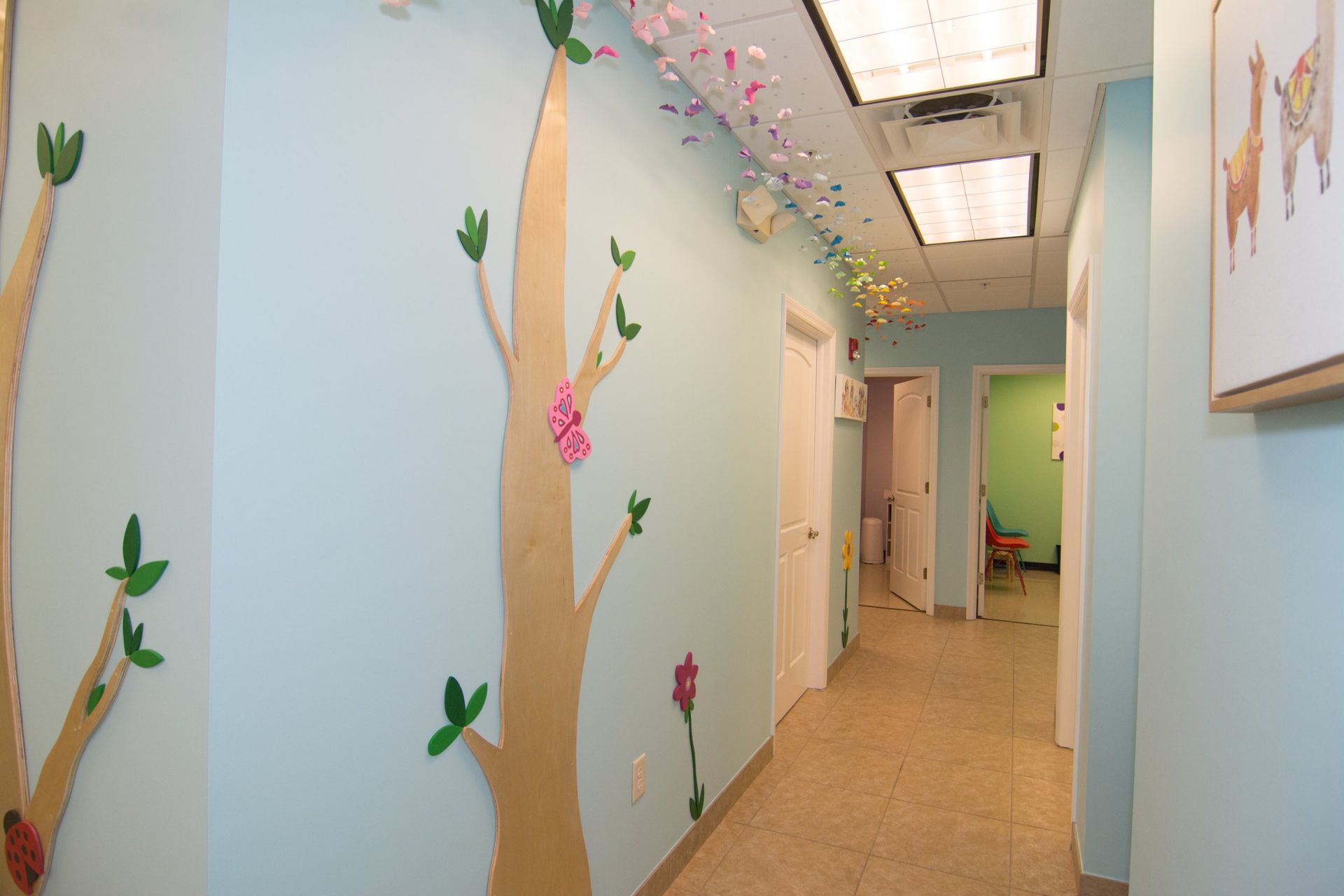 Optima Care Pediatric's hallway, blue walls showing two white doors on both sides