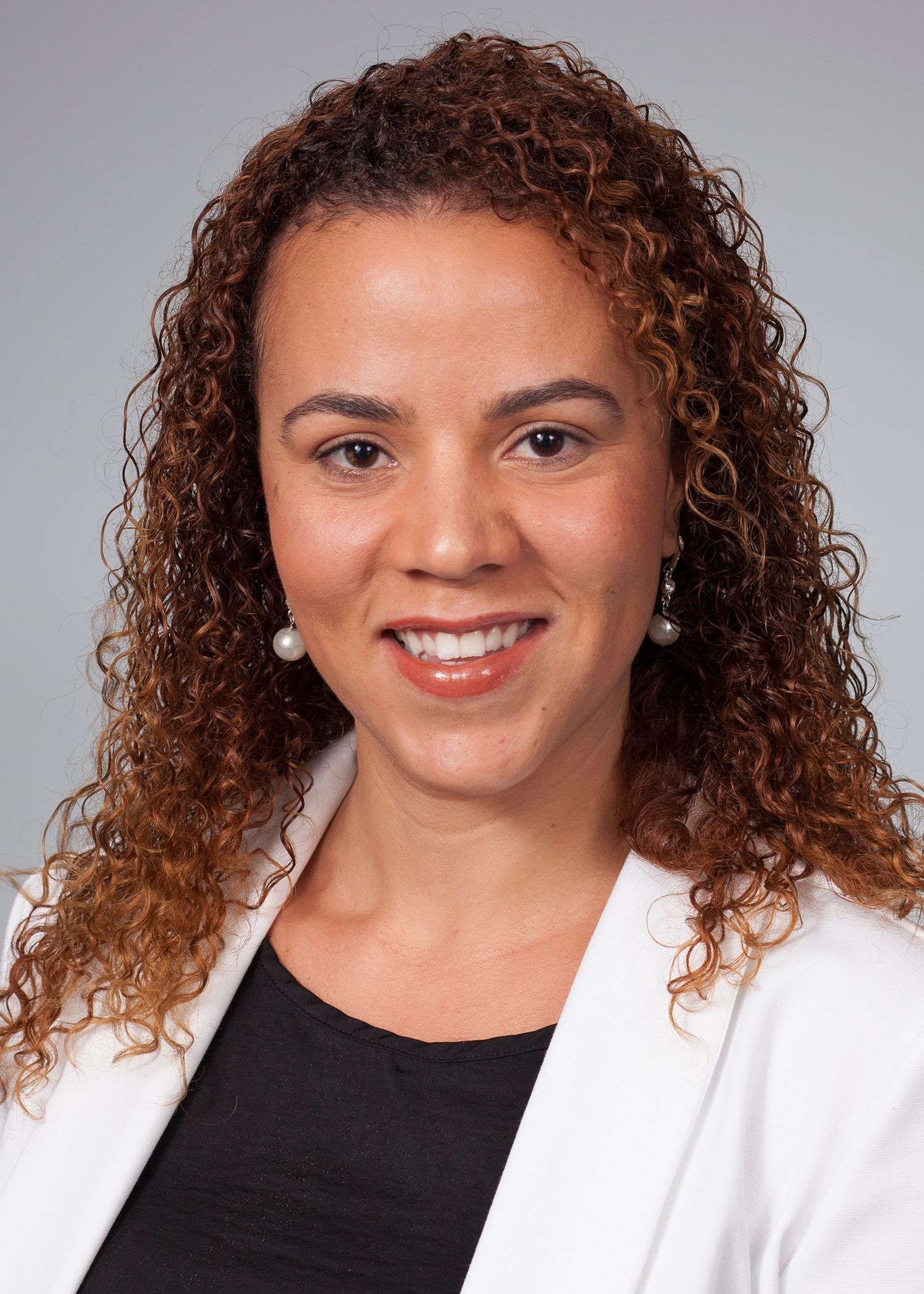 Portrait of DR. MONIQUE MONDESIR wearing a black coat