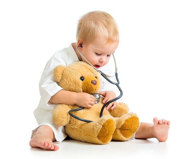 cute baby holding a teddy bear and playing doctor with a stethescope