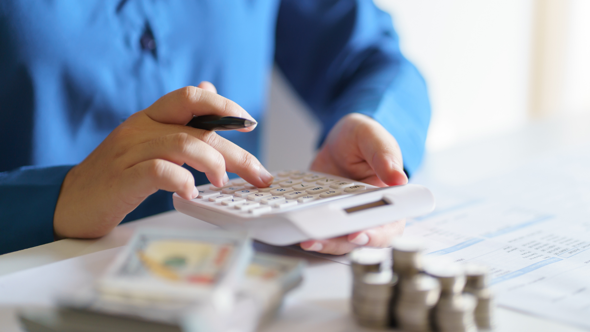 A person is using a calculator while sitting at a table.