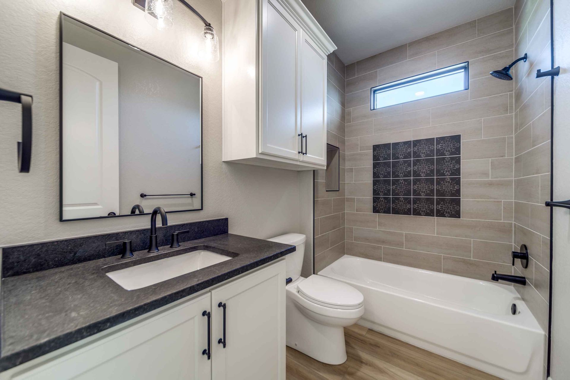 A bathroom with a toilet , sink , and bathtub.