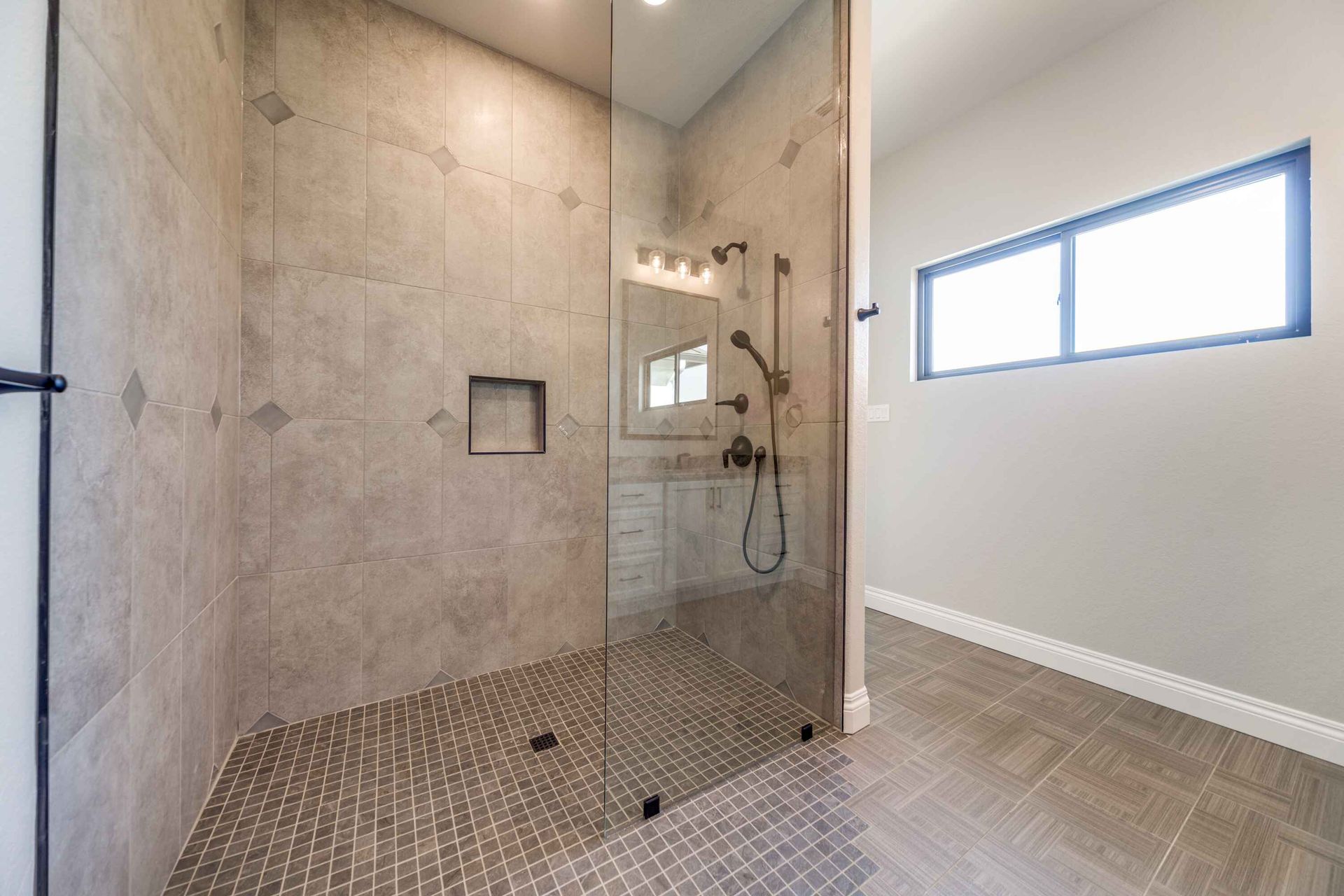A bathroom with a walk in shower and a window.
