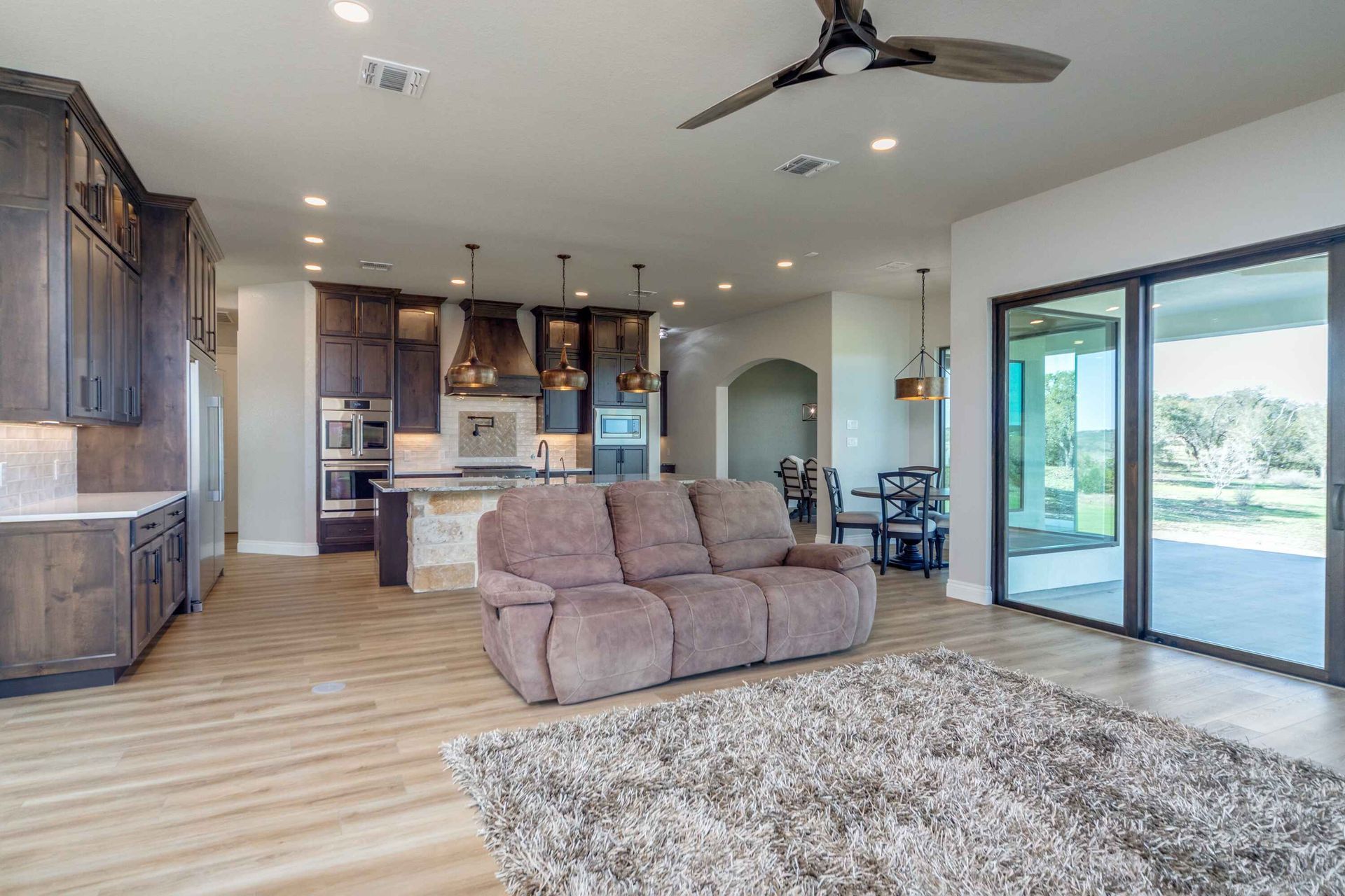 A living room with a couch , rug , and ceiling fan.