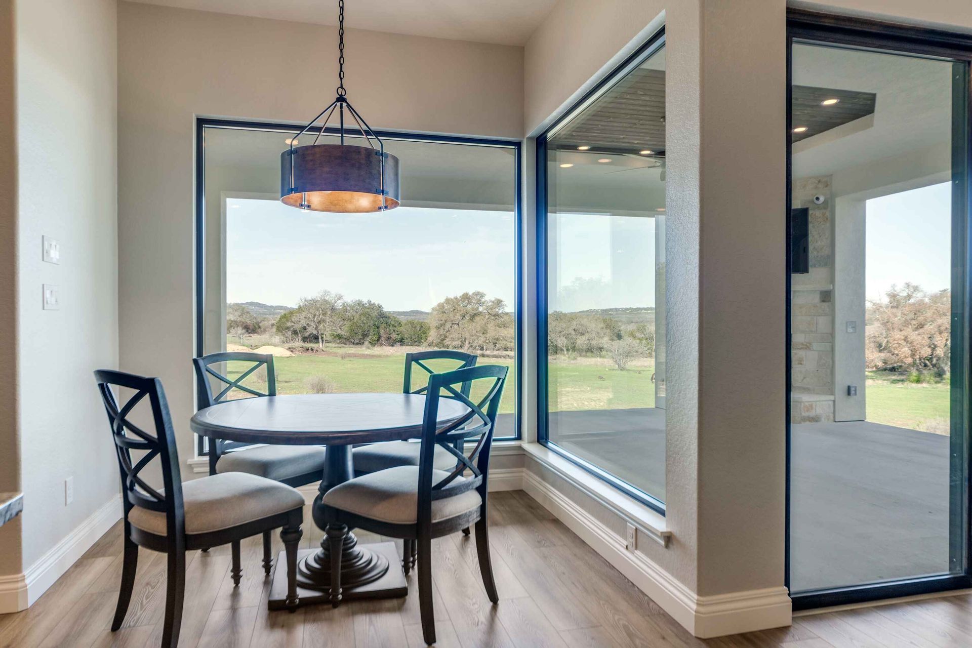 A dining room with a table and chairs and a large window.