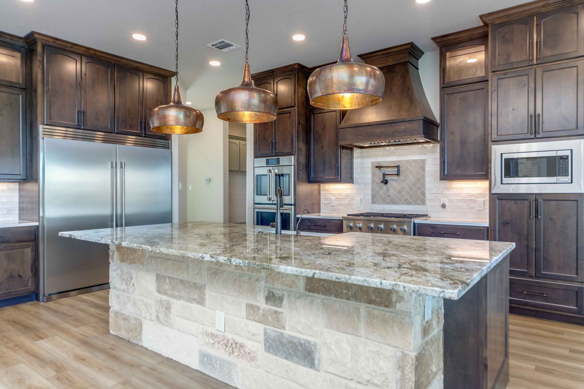 A kitchen with a large island and stainless steel appliances.