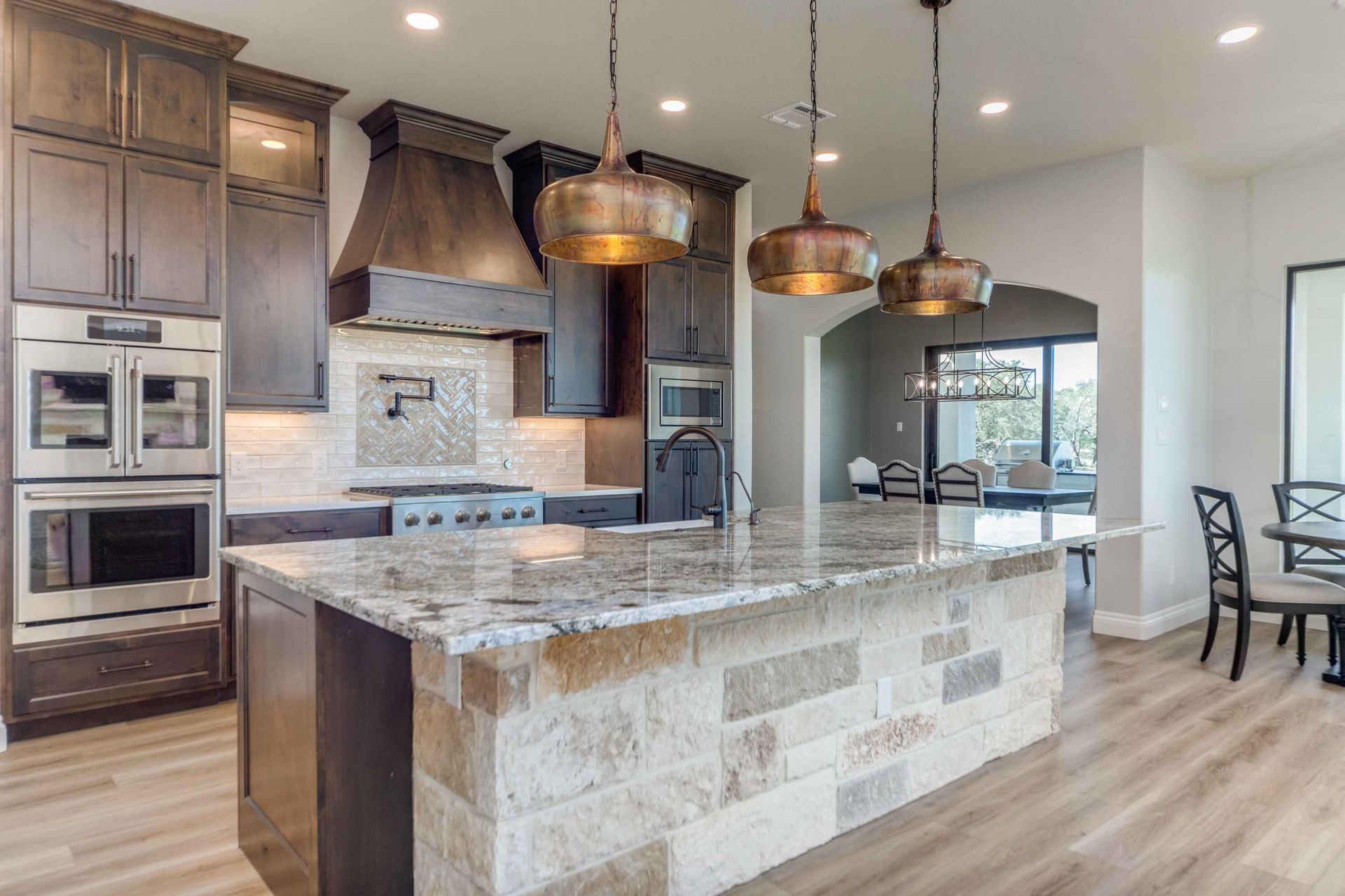 A kitchen with granite counter tops , stainless steel appliances , and a large island.