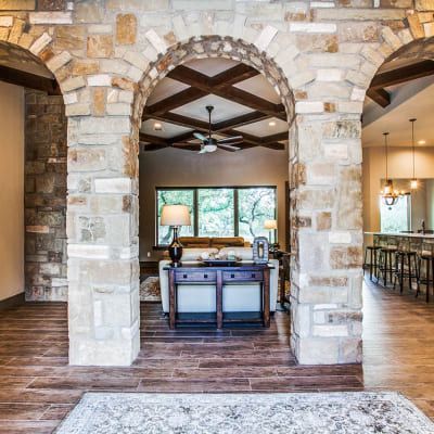 A living room with a brick archway leading to a dining room.
