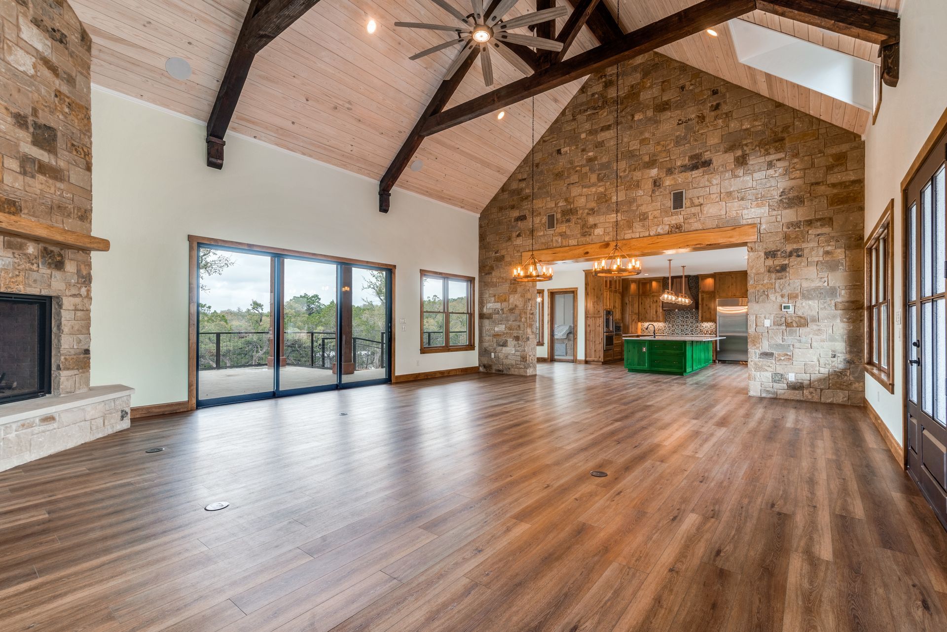 A large empty living room with hardwood floors and a vaulted ceiling.