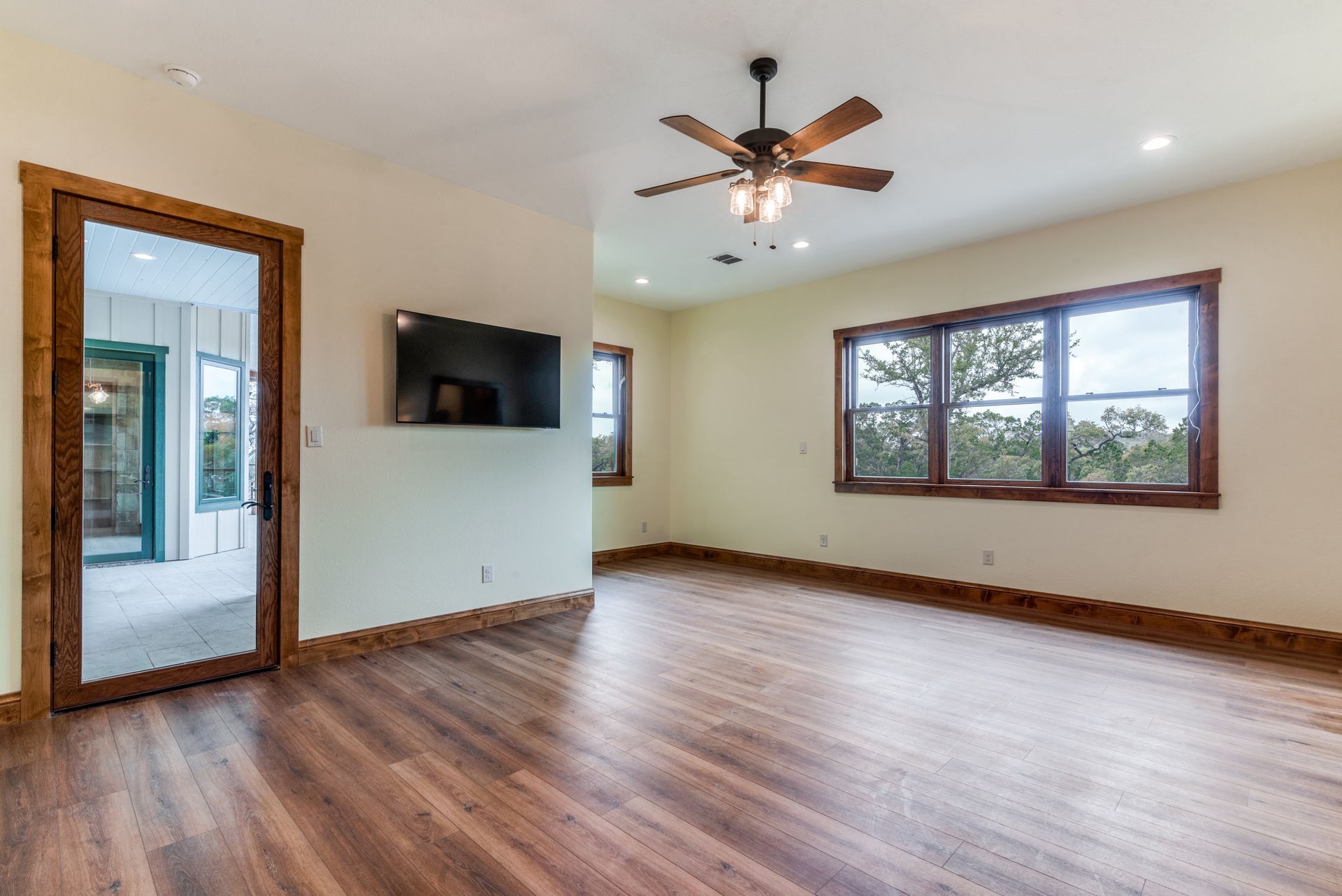 An empty living room with hardwood floors and a ceiling fan.