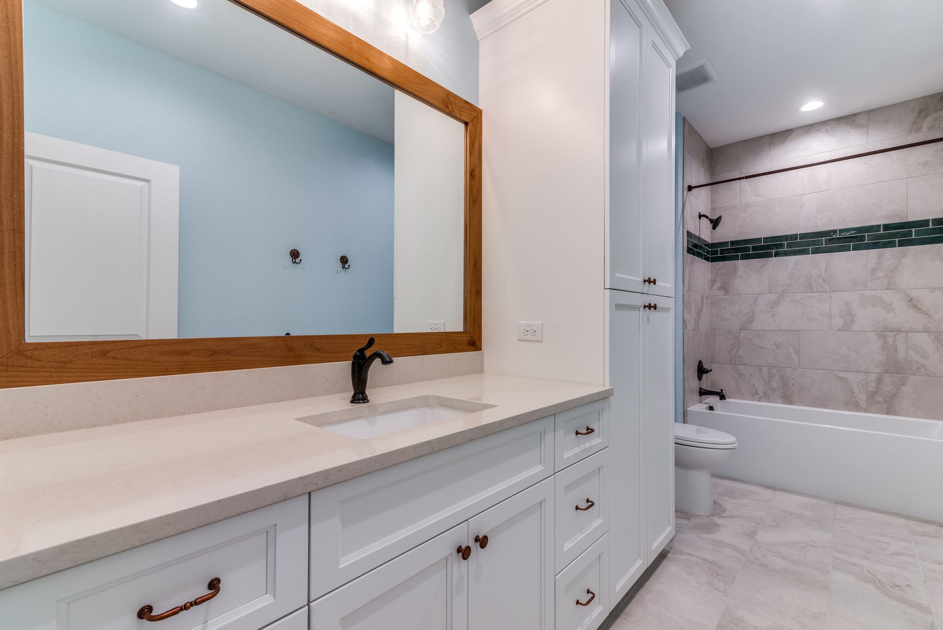 A bathroom with a sink , mirror and bathtub.