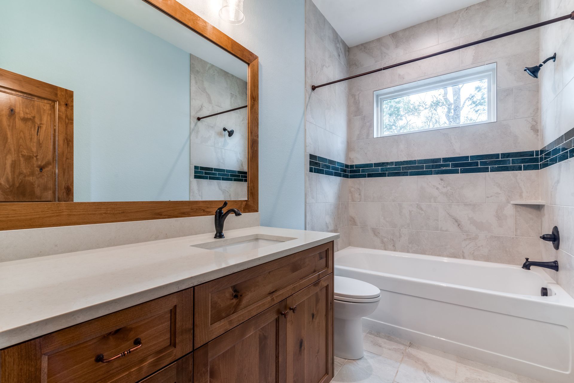 A bathroom with a sink , toilet , tub and mirror.