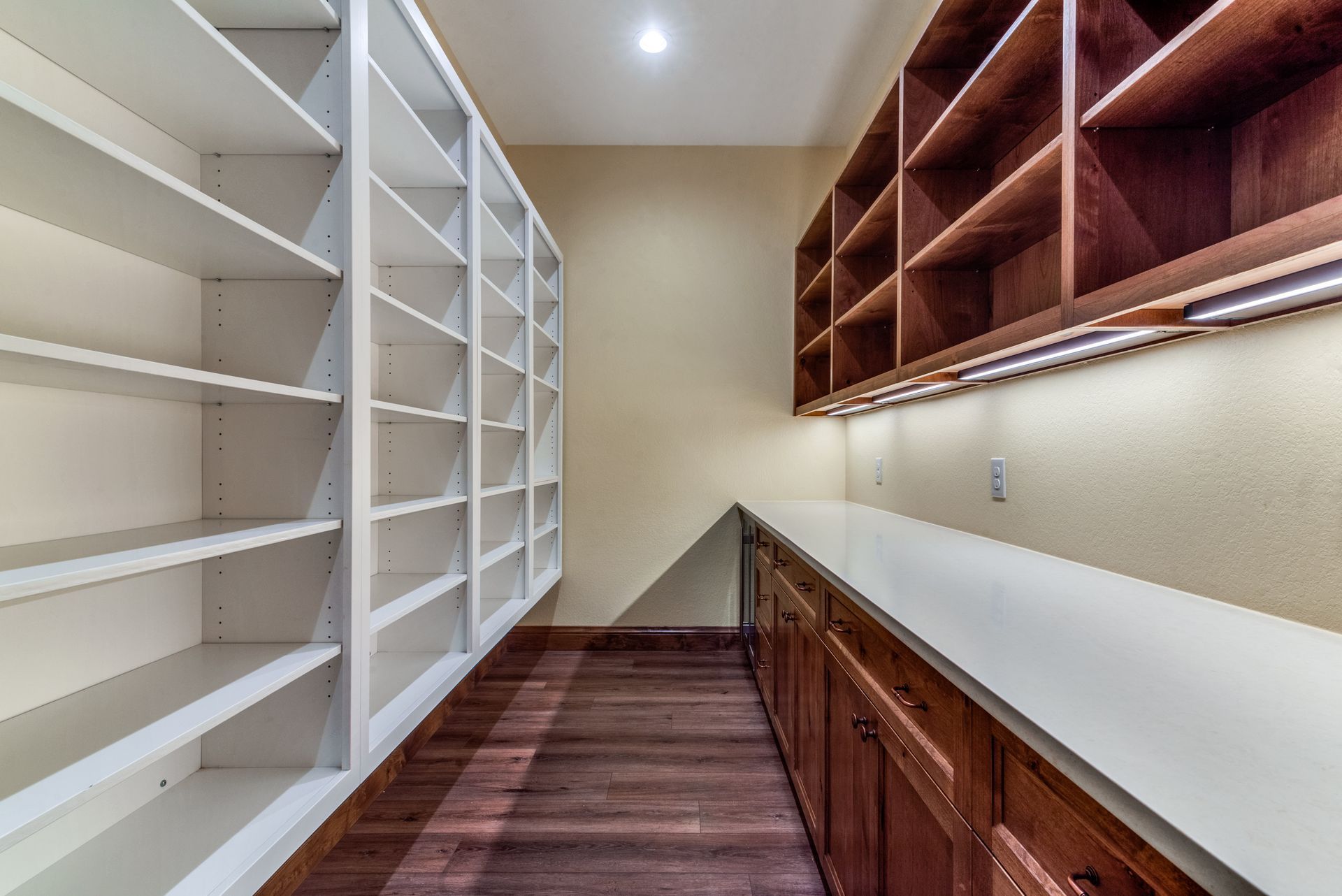 A long narrow room with lots of shelves and cabinets