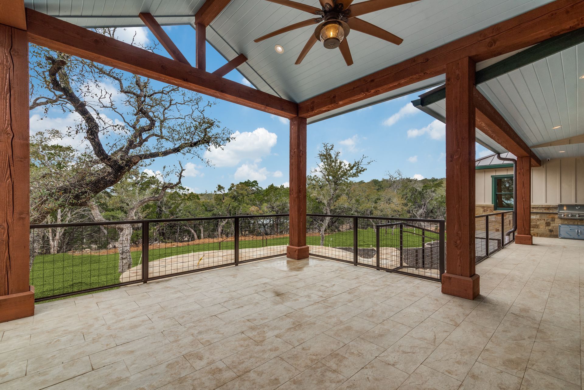 A large covered porch with a ceiling fan