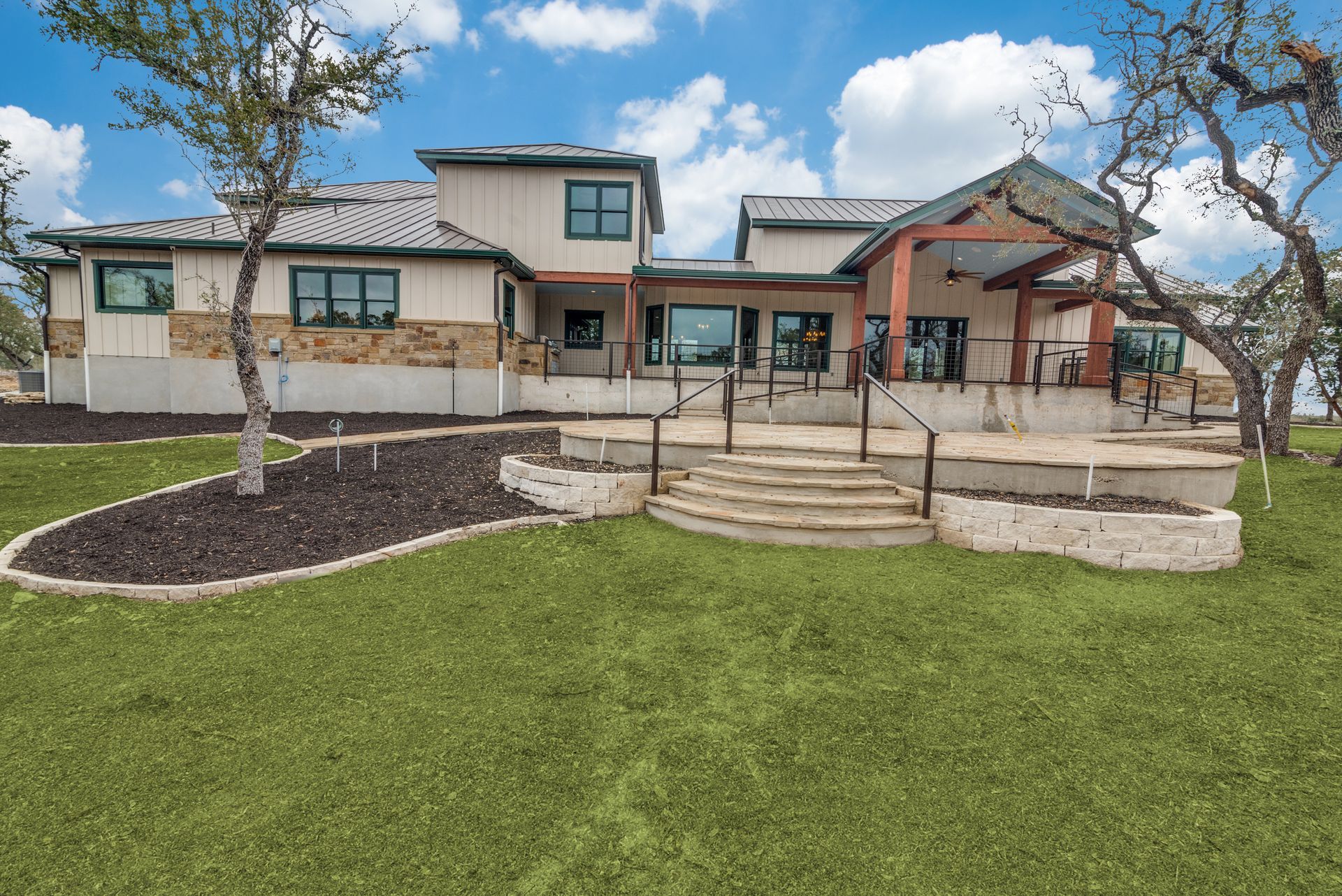 A large house is sitting on top of a lush green field.