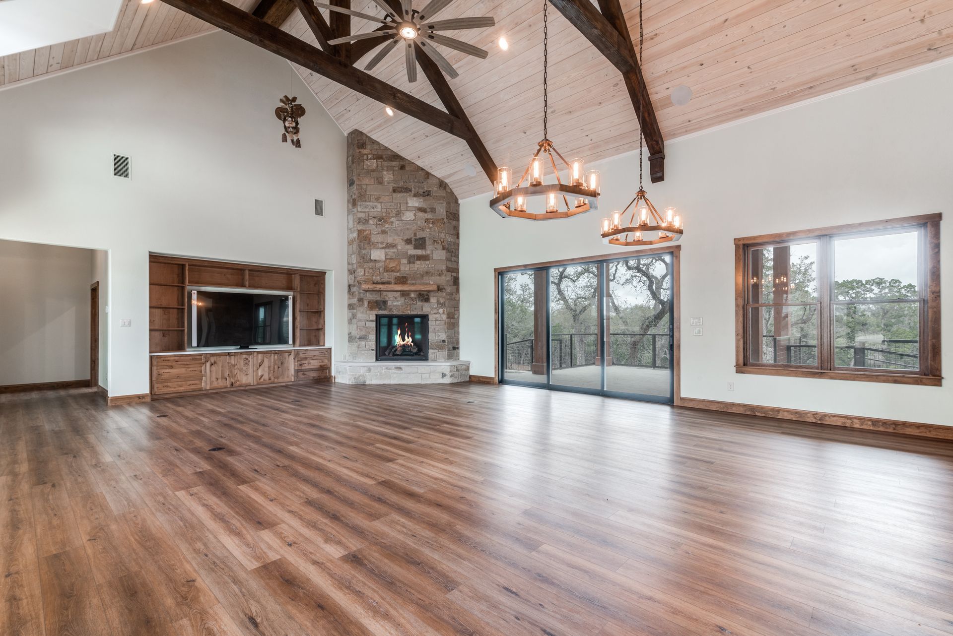 A large empty living room with hardwood floors and a fireplace.